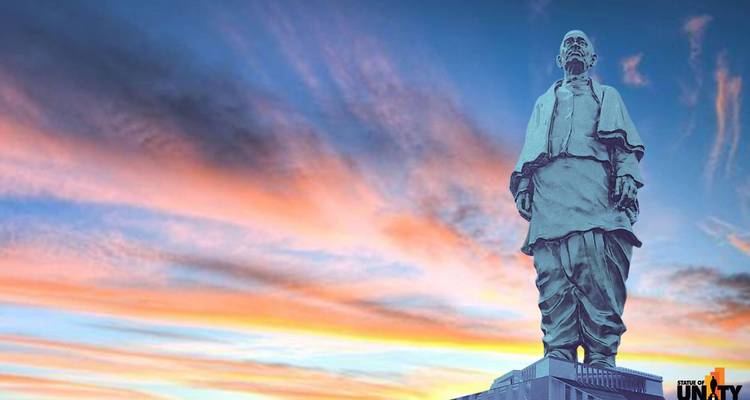 Eine monumentale Statue mit einem dramatischen Sonnenuntergangshimmel im Hintergrund.