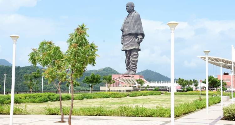 Statue dans un parc avec un ciel dégagé et un environnement verdoyant.