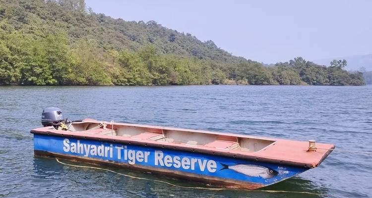 Boot mit "Sahyadri Tiger Reserve" an der Seite auf einem See.