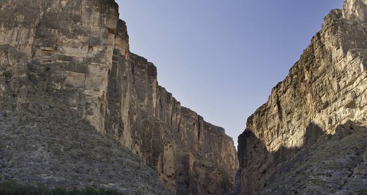 Schlucht mit hoch aufragenden Felswänden und klarem Himmel.