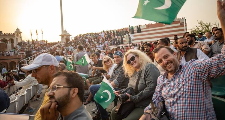 Begeisterte Menschenmenge, die bei einer öffentlichen Versammlung mit Fahnen winkt.