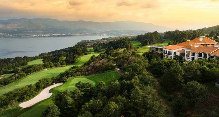 Resort de golf con vistas panorámicas a un vasto lago y colinas boscosas ondulantes al atardecer cerca de Kunming.