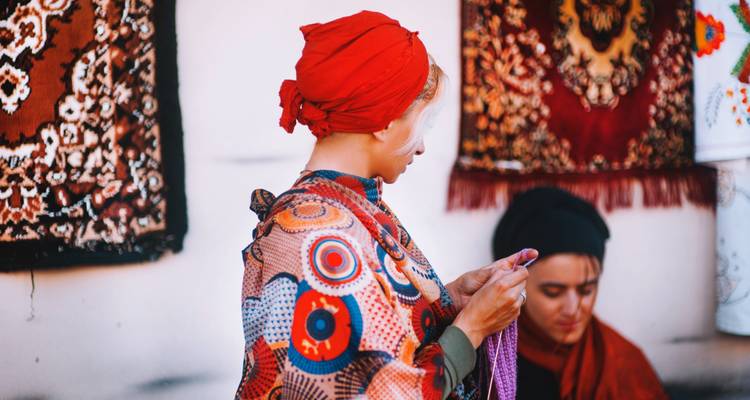 Twee mensen die interacteren met traditionele textiel die tentoongesteld wordt.