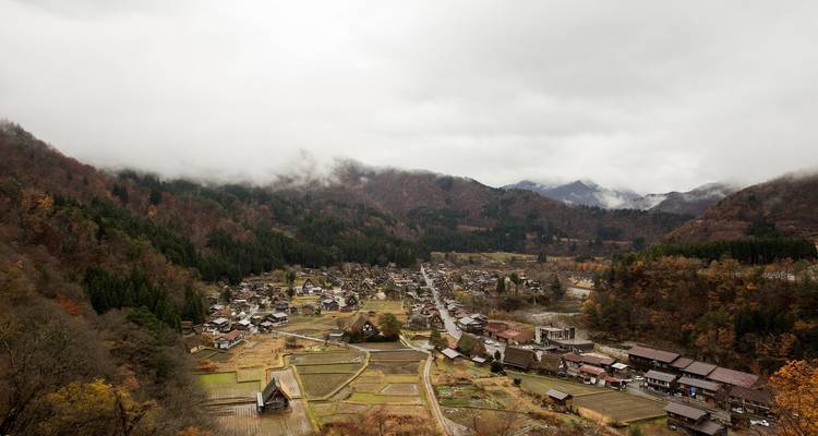 Vista panorámica de un pueblo enclavado en un valle rodeado de montañas.