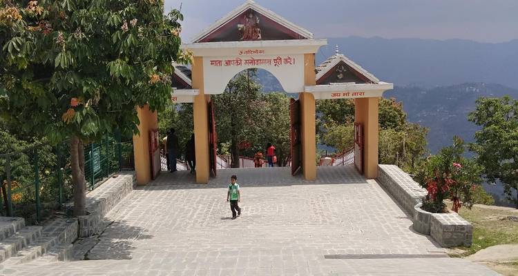 Kind geht auf eine tempelartige Struktur zu, mit Bergen im Hintergrund.