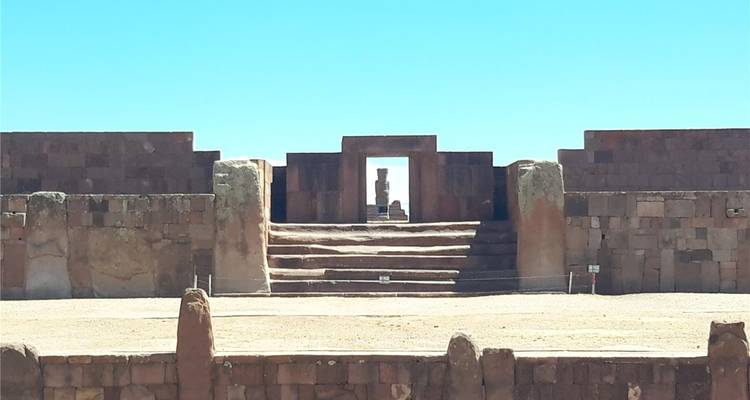 Steintreppe und Monolithen der archäologischen Stätte Tiwanaku unter klarem Himmel.