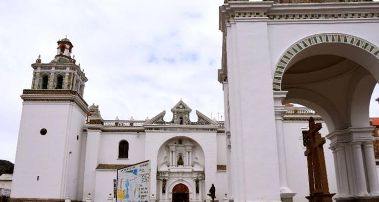 Basilique de Copacabana aux murs blanchis à la chaux, avec des tours ornées et une entrée cintrée sur un ciel pâle.