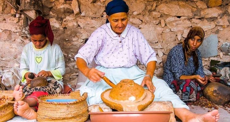 Women preparing traditional food in a rustic setting.