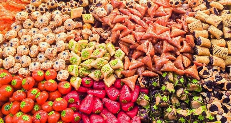 Assortment of colorful traditional pastries arranged closely.