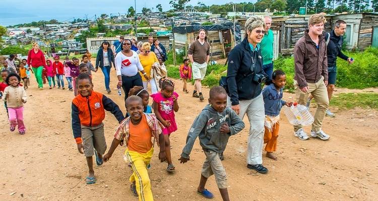 Kinder und Erwachsene gehen im Freien in einer ländlichen Umgebung spazieren.