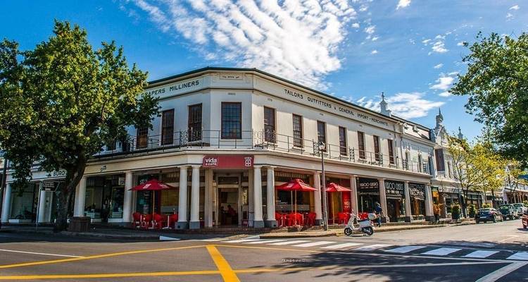 Historisches Gebäude in einer Stadt mit Außenbestuhlung.