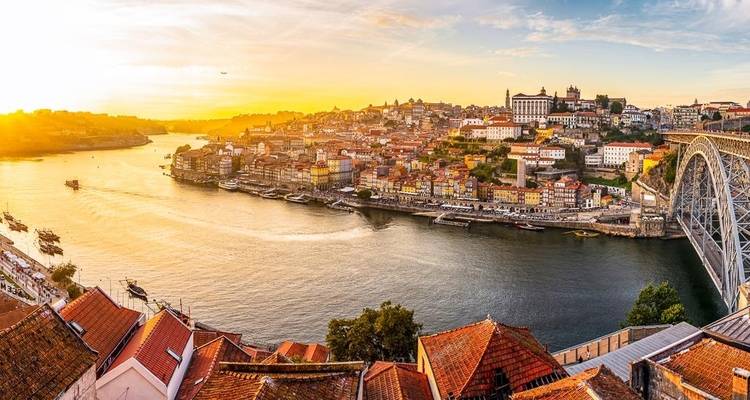 Vue panoramique d'une rivière et d'une ville au coucher du soleil.