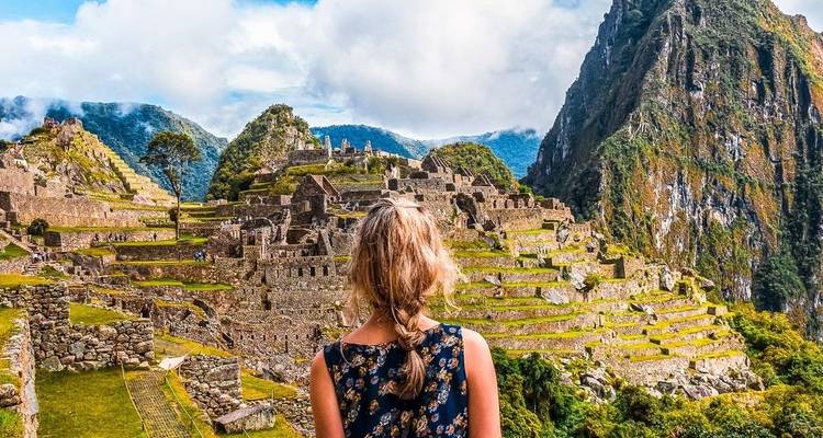 Frau bewundert die Ruinen von Machu Picchu