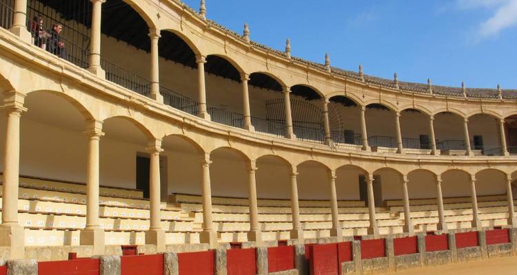 Une vue intérieure d'une arène historique avec des arches et des gradins.