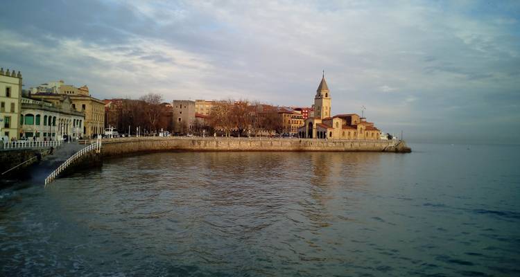 Ville côtière avec une église et une promenade le long de l'eau.