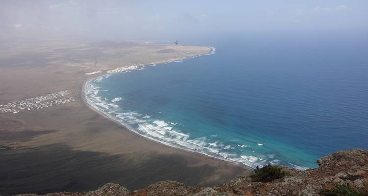 Aerial view of a coastal area with waves crashing on the shore.