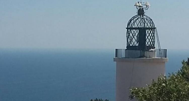 Phare contre un ciel dégagé et un arrière-plan océanique.