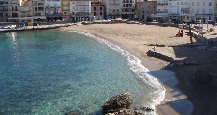 Plage ensoleillée avec des bâtiments en arrière-plan.