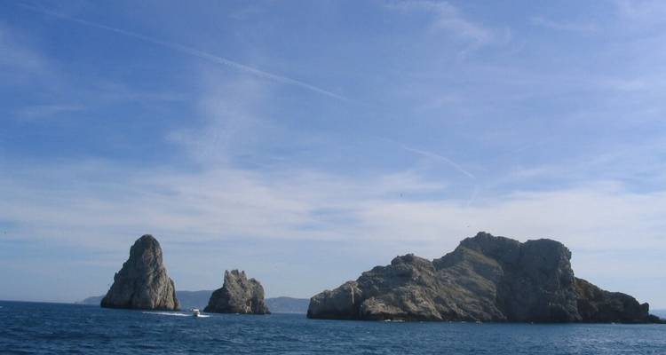 Des rochers qui s'élèvent de l'océan sous un ciel dégagé.