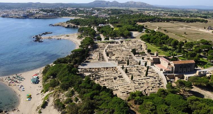 Aerial view of a coastline with ancient ruins and city.