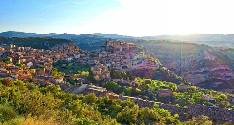 Vue pittoresque d'une ville médiévale située sur une colline au coucher du soleil.