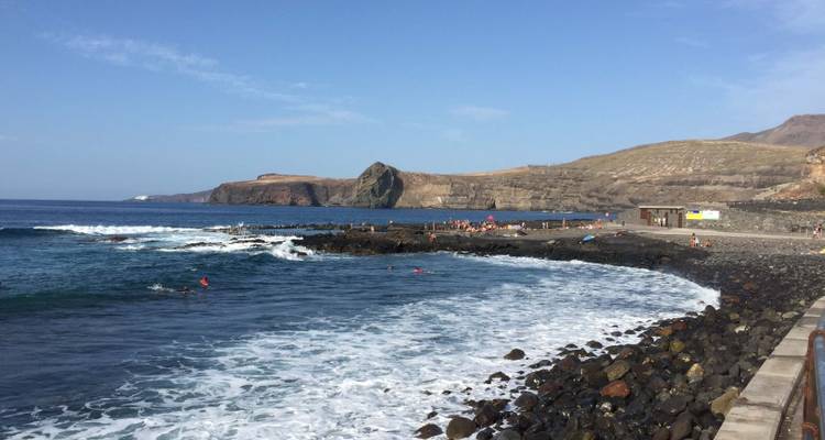 Scène côtière avec rivage rocheux et petites vagues.