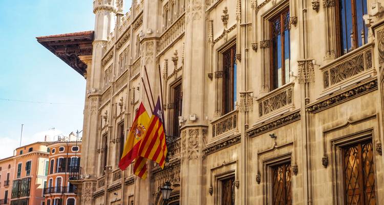 Detail of a historical stone building adorned with flags.