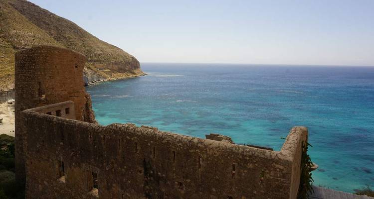Ruines d'un vieux château de pierre avec vue sur la mer bleue claire.