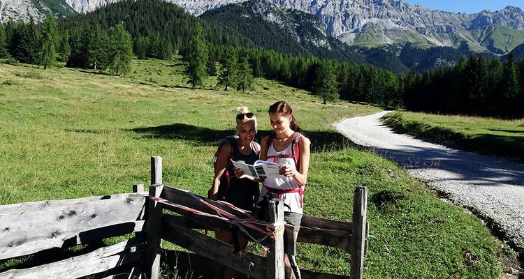 Deux personnes avec une carte dans un champ montagneux.