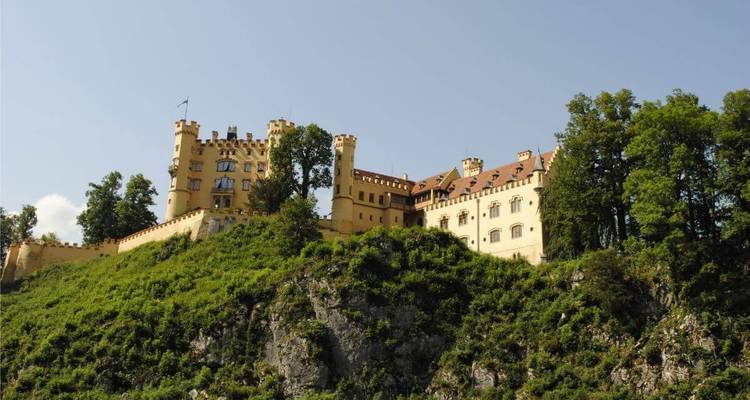 Un château historique sur une colline avec des arbres autour.