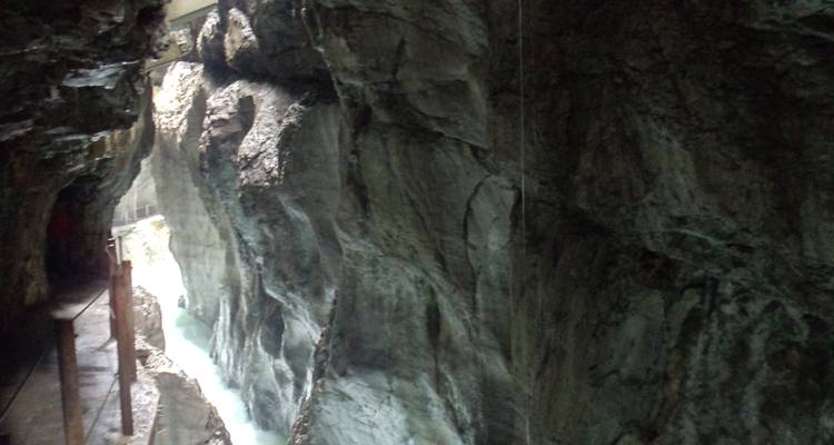 Canyon sombre avec écoulement d'eau visible.