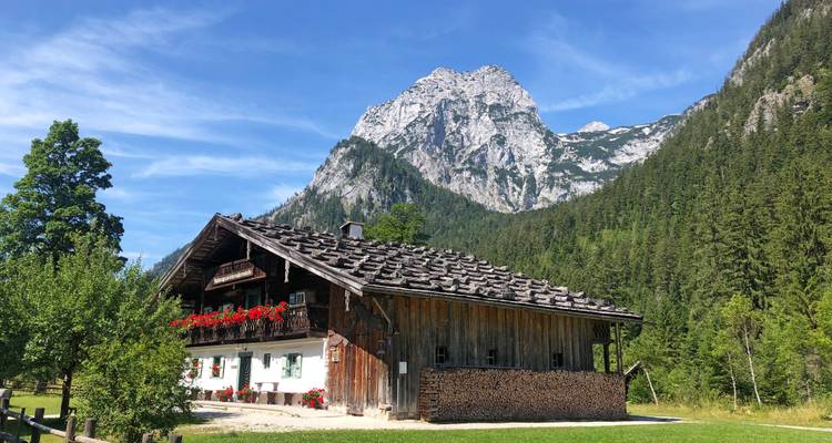 Chalet dans un cadre alpin sous un ciel bleu.