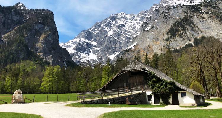 Une grange rustique sur fond de montagnes enneigées.