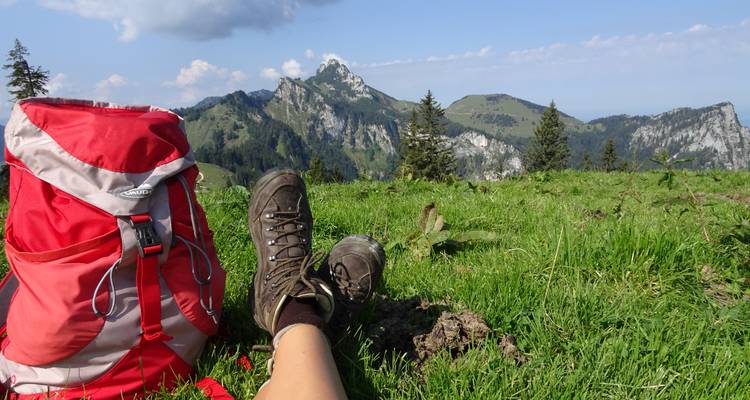 Un randonneur se détendant avec une vue sur les montagnes au loin.