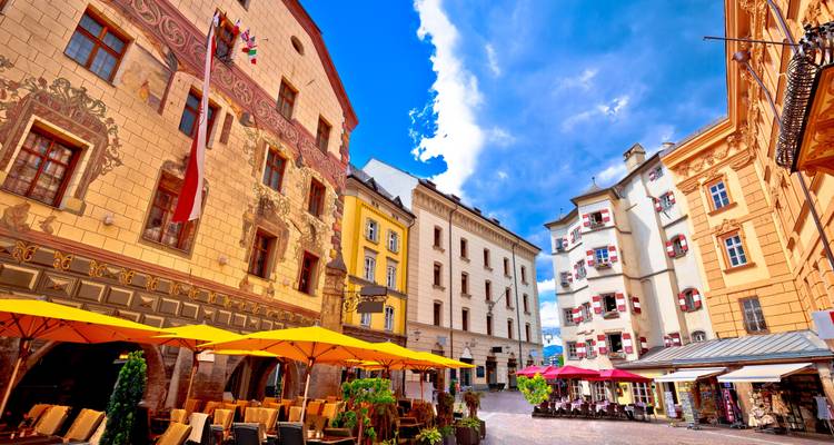 Colorful buildings in Innsbruck with a mountain backdrop.
