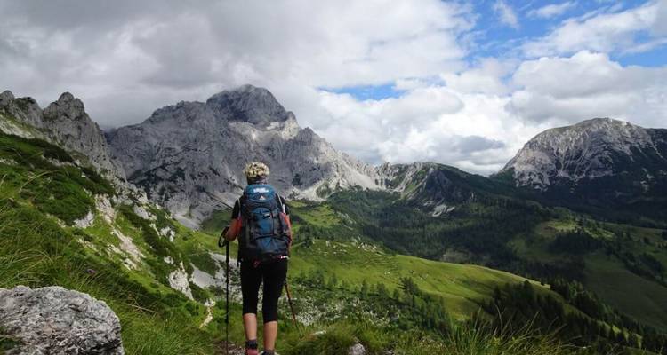 Un randonneur avec un sac à dos traversant une région montagneuse.