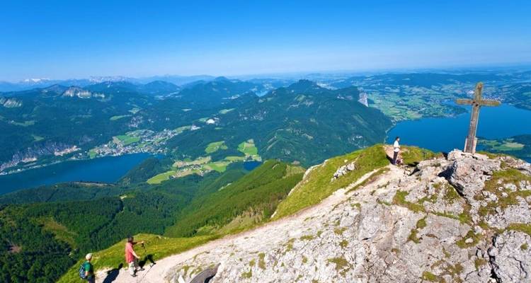 Randonneurs au sommet d'une montagne avec des lacs et des villages en contrebas