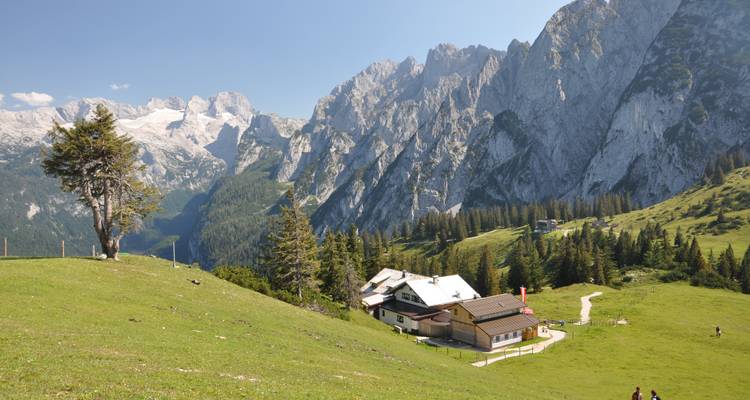 Alpine hut in a mountainous landscape with blue skies.