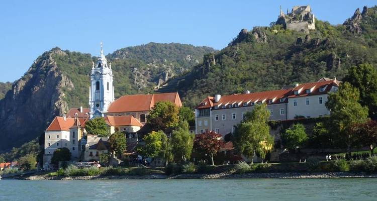 Ville historique avec une église et un château avec des montagnes en arrière-plan.
