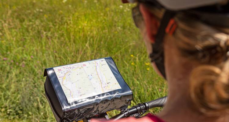Map on a cycling equipment with greenery in the background.