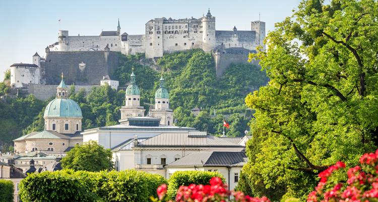 View of Salzburg's iconic fortress with lush greenery.