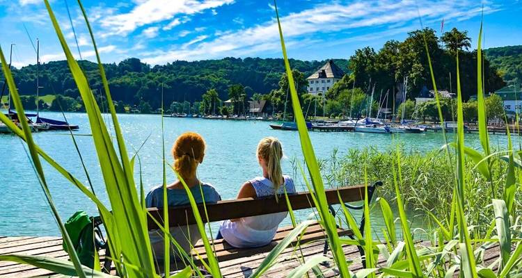 Deux personnes assises au bord d'un lac profitant de la vue.