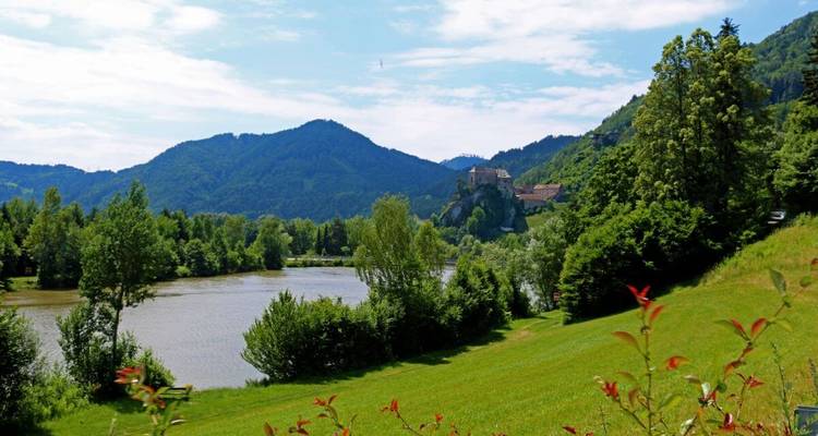 A river winding through a valley with a castle in the distance.