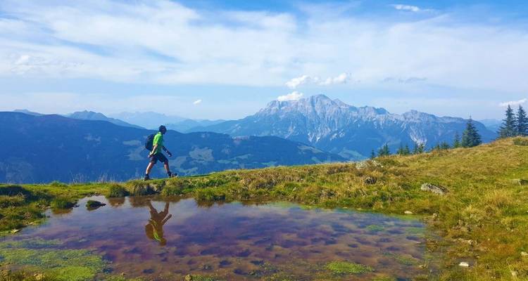 Randonneur avec une grande chaîne de montagnes visible au loin.