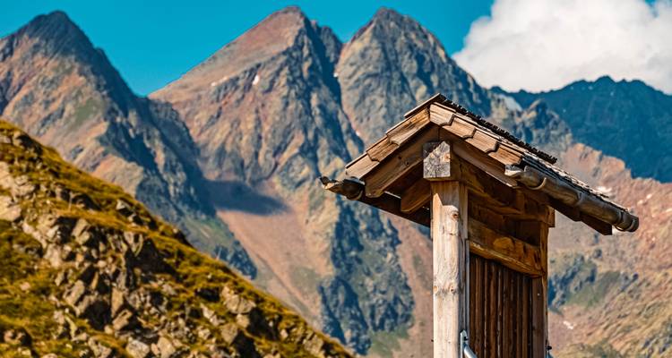 Structure en bois avec des montagnes en arrière-plan.