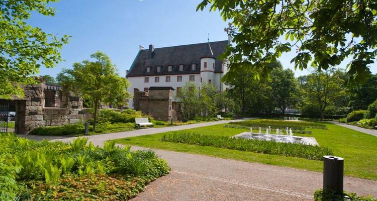 Tuingebied met ruïnes en een historisch gebouw.