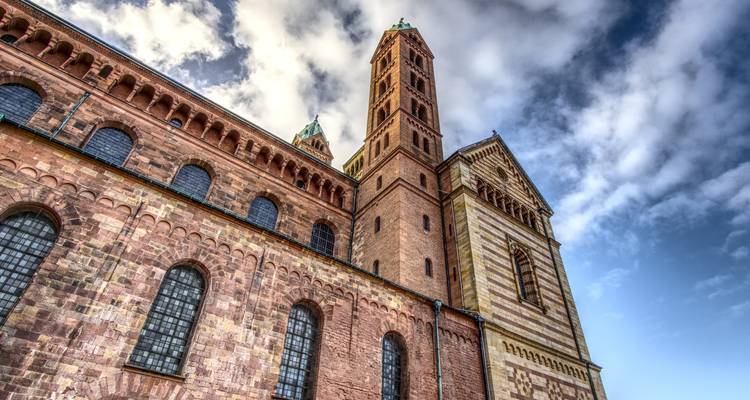 Imposante Kathedrale mit Zwillingstürmen unter einem dramatischen Himmel.