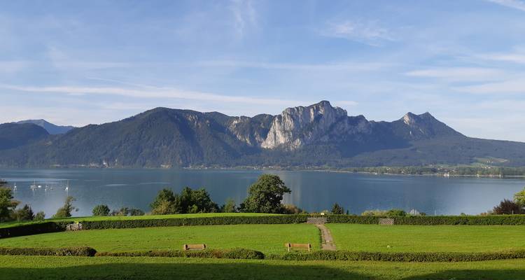 Vue tranquille sur le lac avec montagnes et verdure.