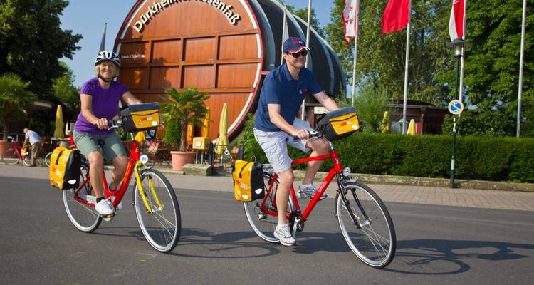 Twee fietsers passeren het gigantische wijnvat van Bad Dürkheim op een zonnige dag.