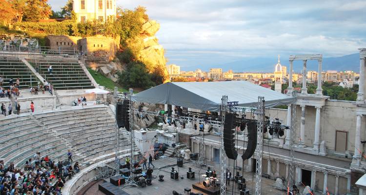 Ancient amphitheater setting with people attending an event.
